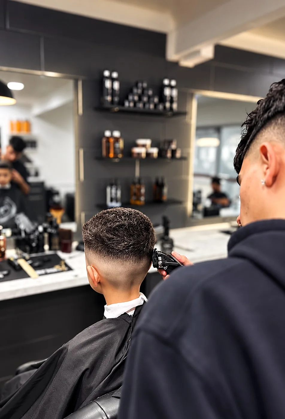 Barber blending a skin fade with clippers